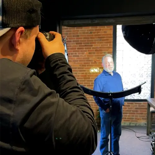 photographer taking headshot of employee with professional lighting