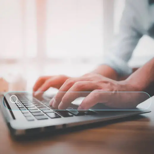 hands on laptop keyboard with a floating semi-translucent search bar