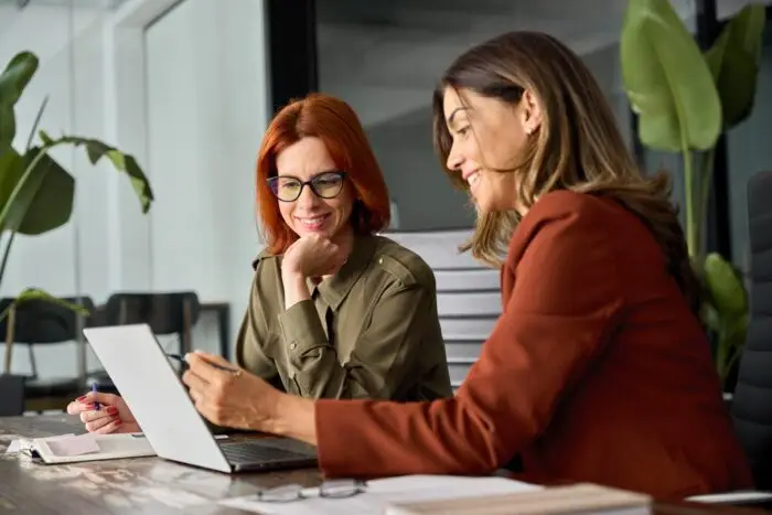 two women working together at a laptop