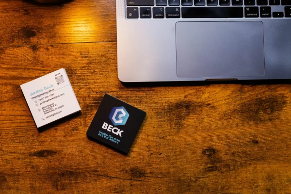 Business cards in front of a computer at the beck digital Asheville office