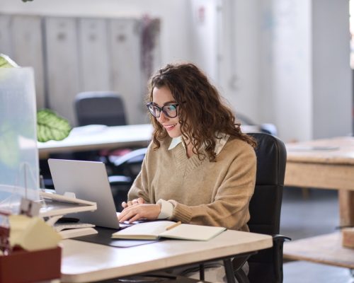 Young,Happy,Professional,Business,Woman,Employee,Sitting,At,Desk,Working