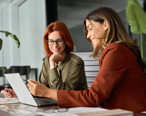 two women working together at a laptop